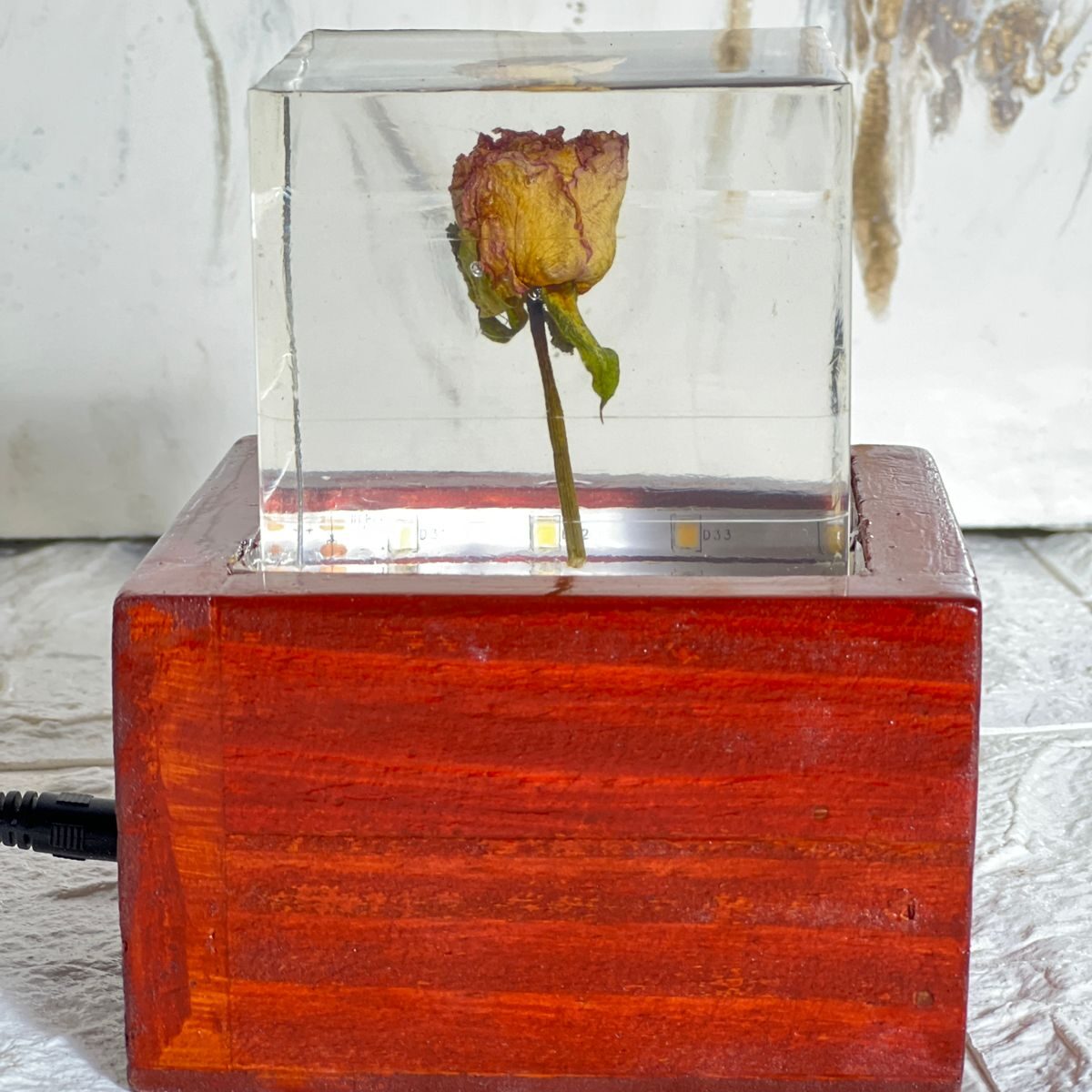 Deep casting block with preserved real rose, displayed on a wooden LED stand