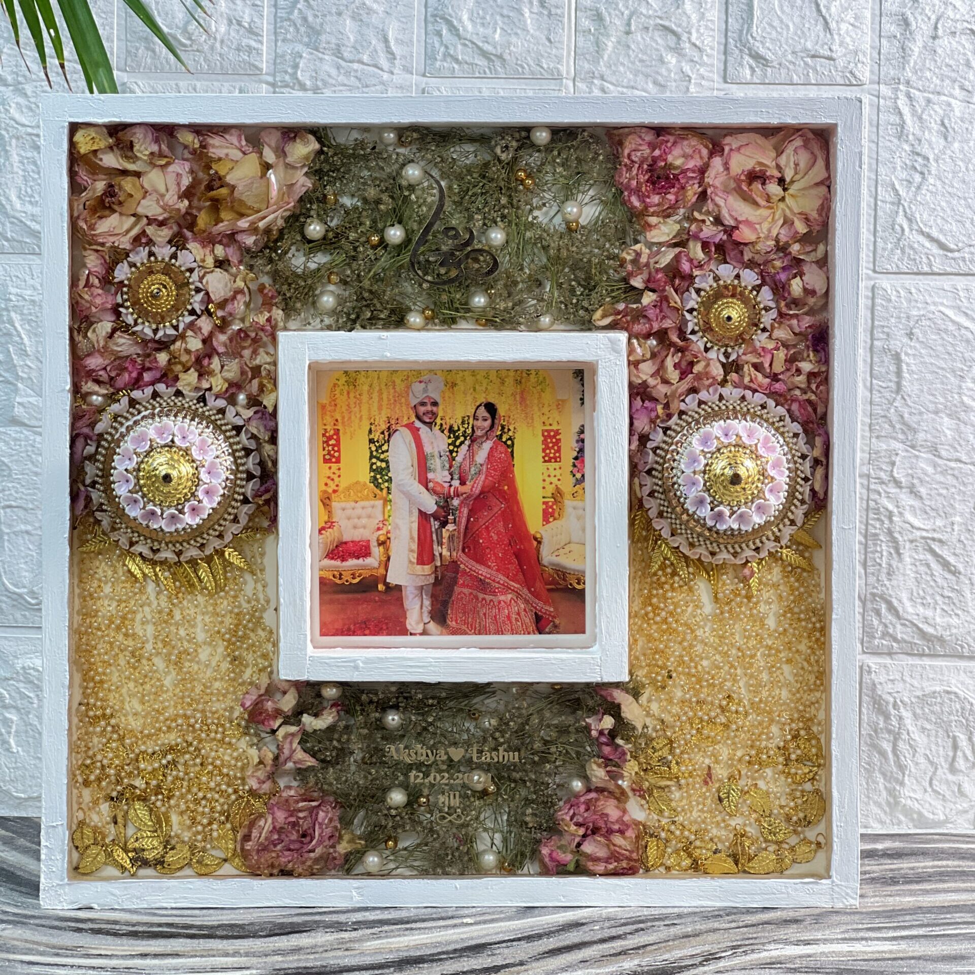 Wooden frame with bride’s kaleerein and wedding garland preservation