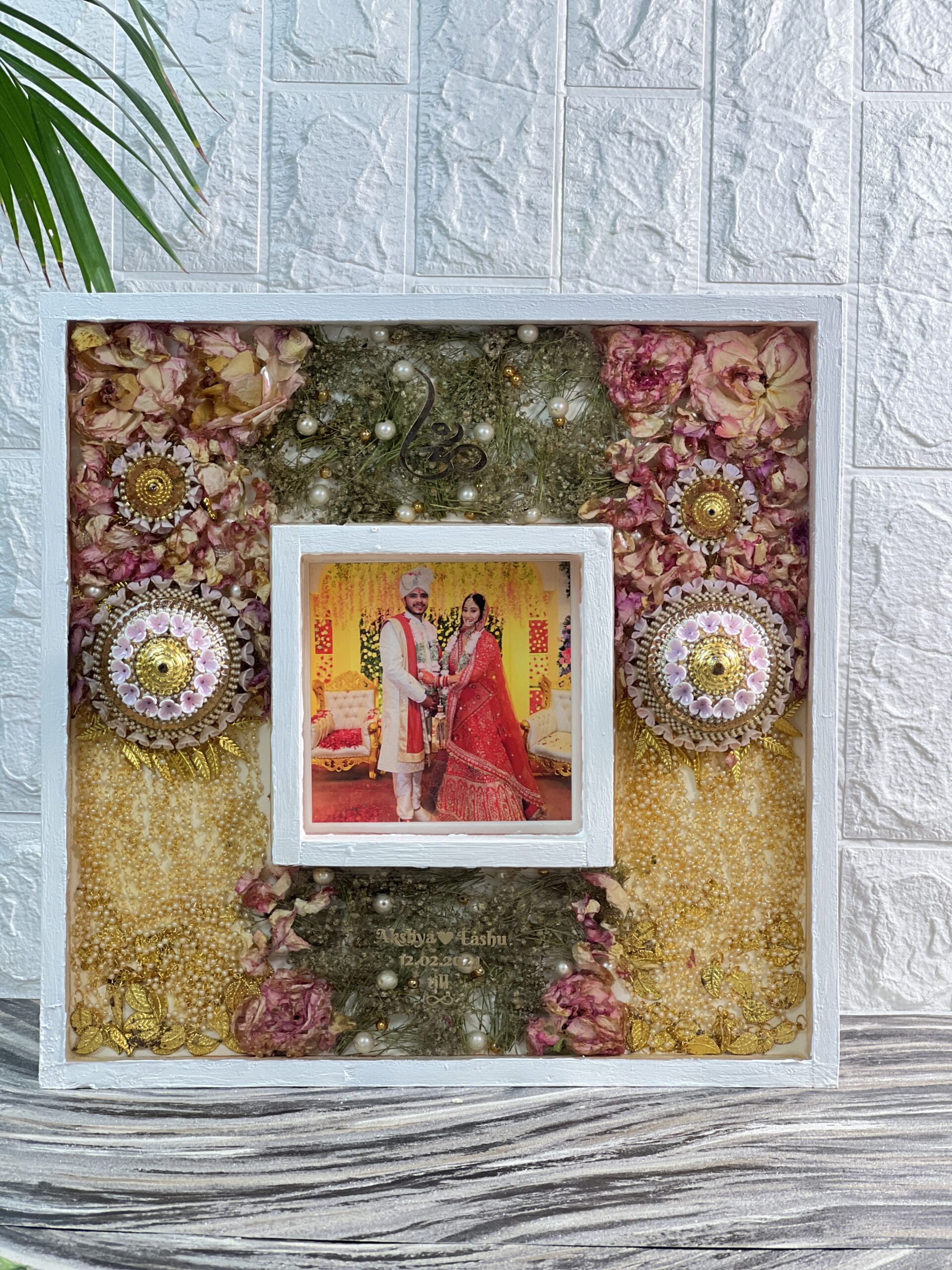 Wooden frame with bride’s kaleerein and wedding garland preservation