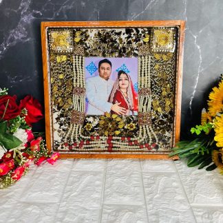Square teakwood frame with preserved wedding varmala, photo, groom's mala, kaleerein, and LED light