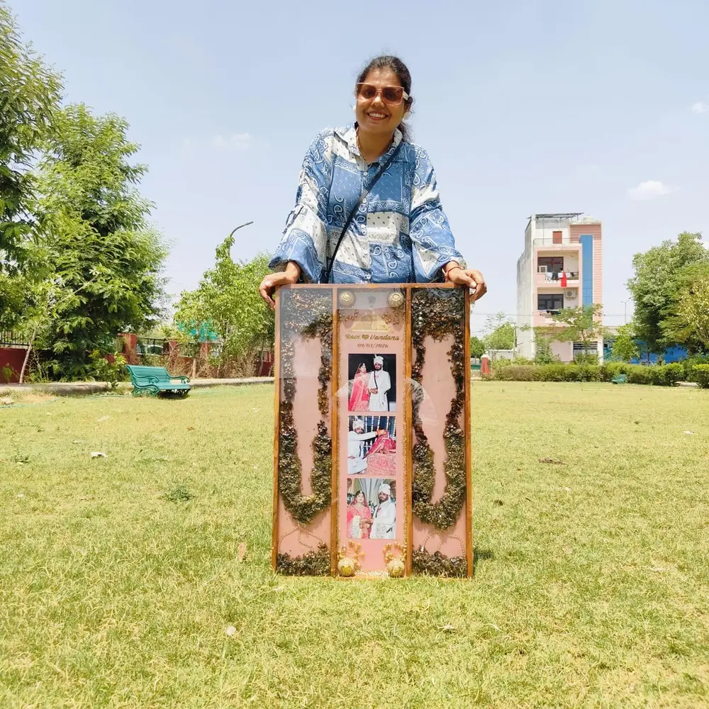 Full varmala preserved in a tall frame with couple photos
